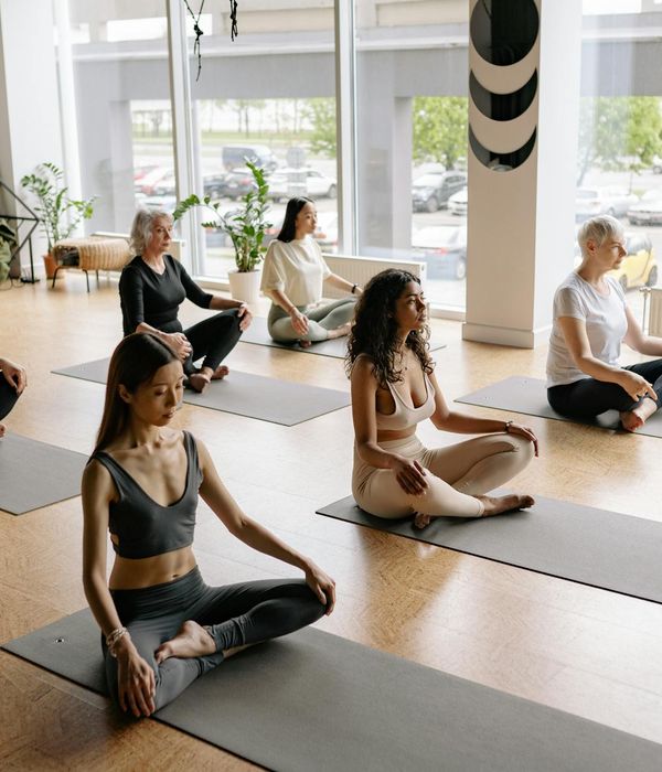 Woman in a peaceful yoga pose on a mat.